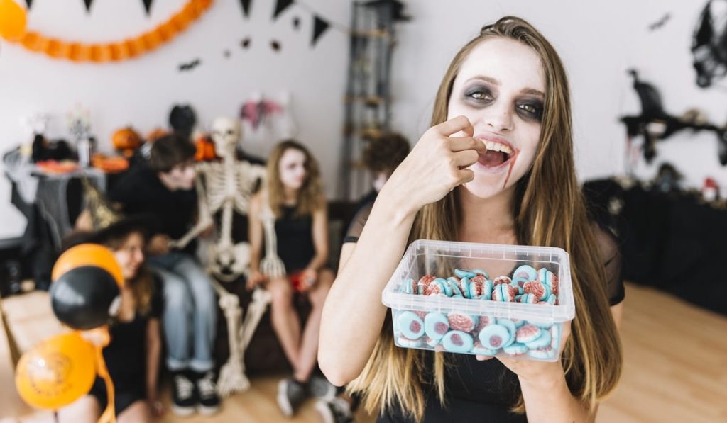 Jóvenes celebrando Halloween y comiendo dulces. Foto: Freepik 